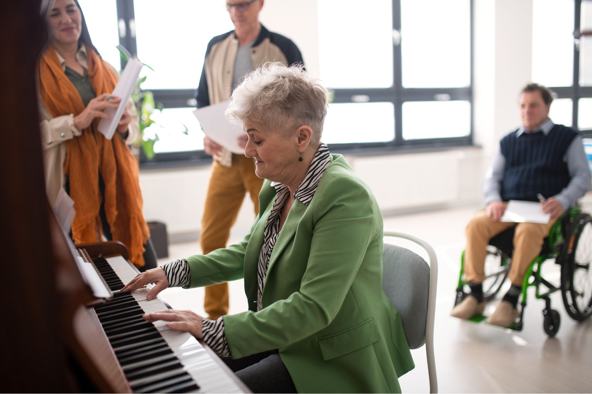 Senior woman playing at piano in choir rehearsal.
